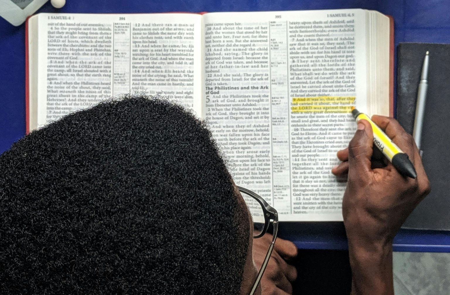 Homme étudiant un livre et surlignant une partie. Premiers pas dans le monde professionnel