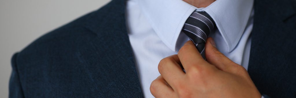 Homme en costume professionnel nouant sa cravate.